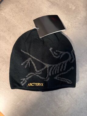 Arc'teryx Black Beanie with Gray Skeletal Logo and Gold Embroidered Name